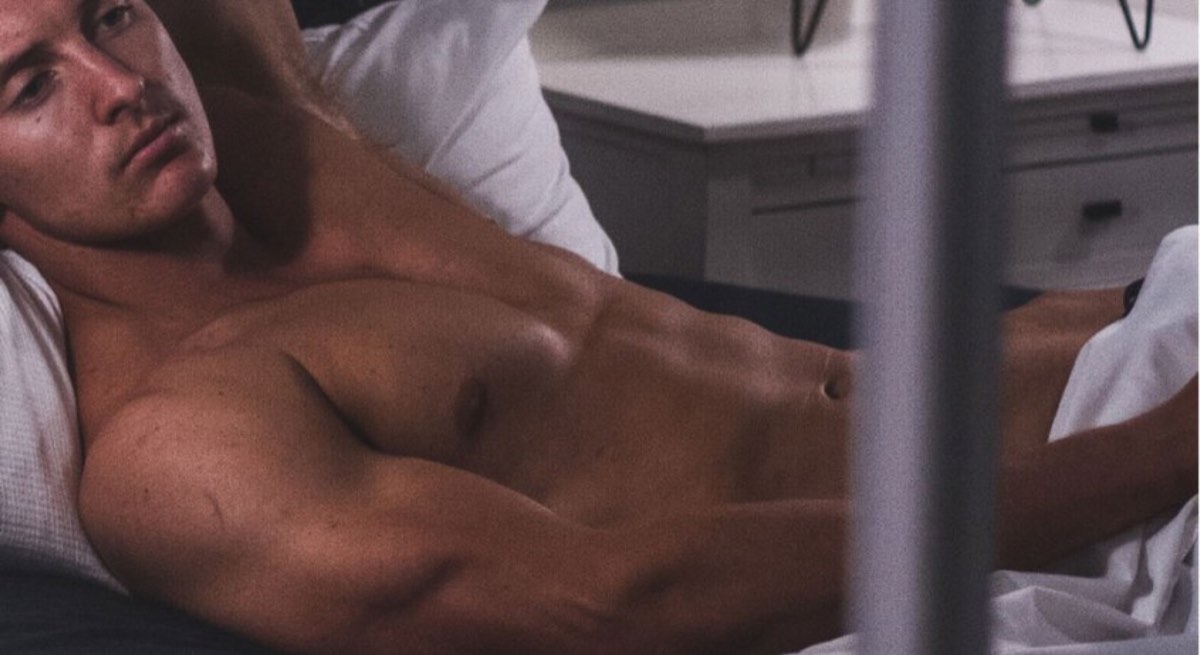 shirtless man lay on bed