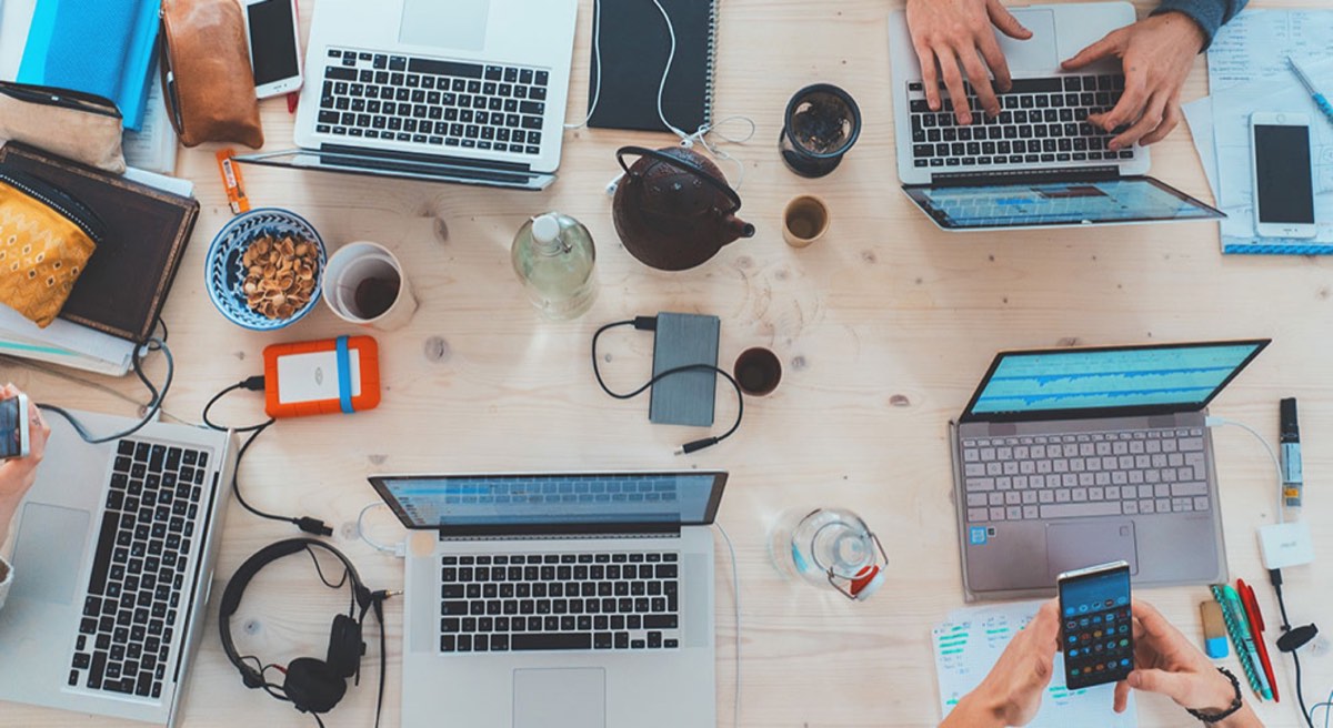People sitting down near table with laptop