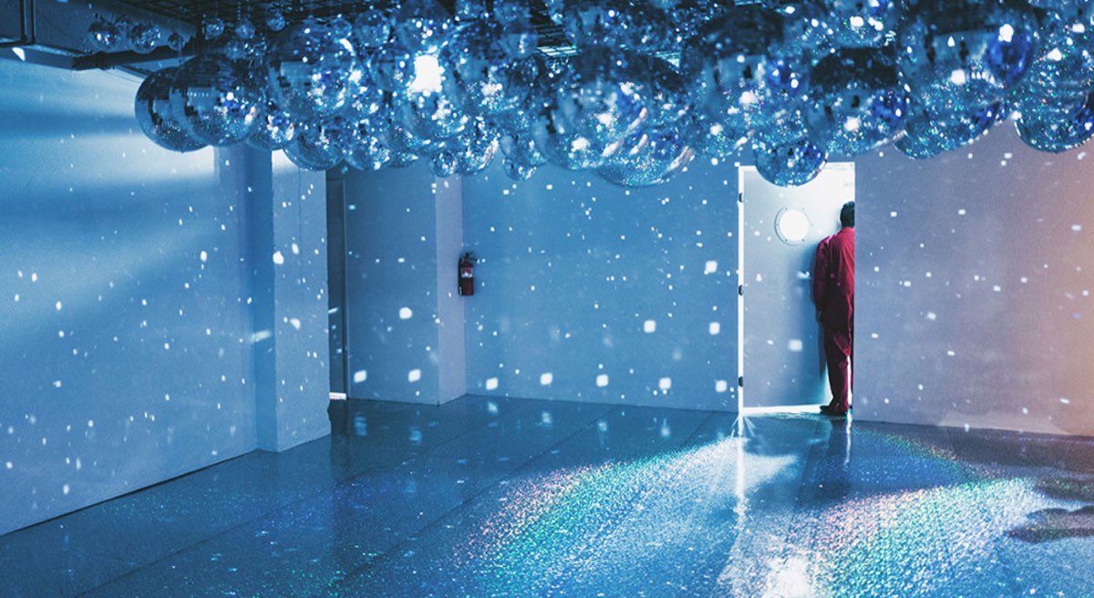 man standing while looking behind wooding door in lighted room