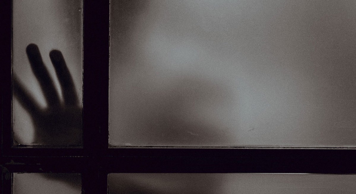 Person touching frosted glass door
