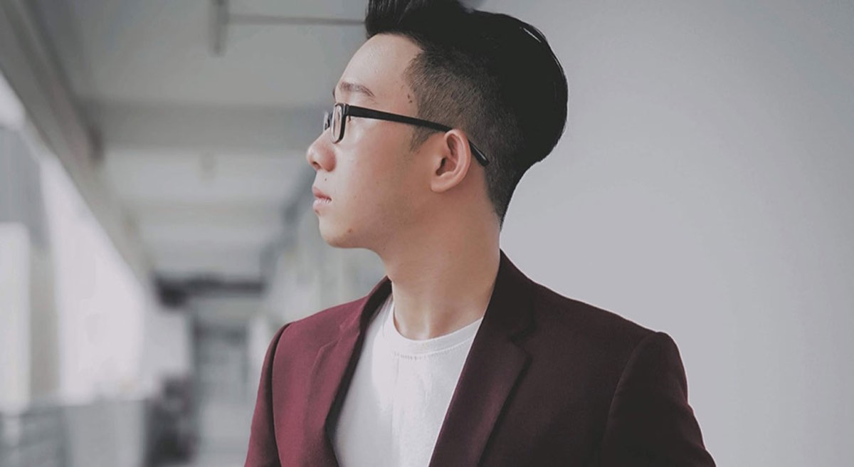 man buttoning his maroon formal suit jacket